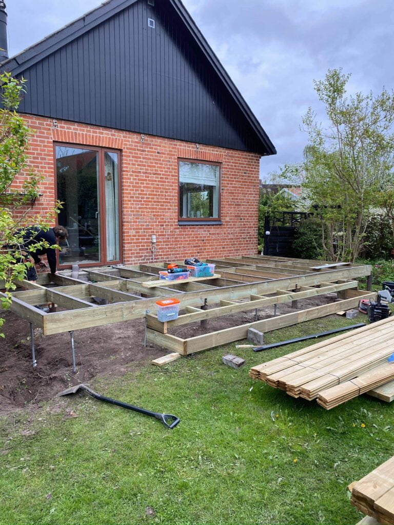 Bygning af træterrasse ved murstenshus