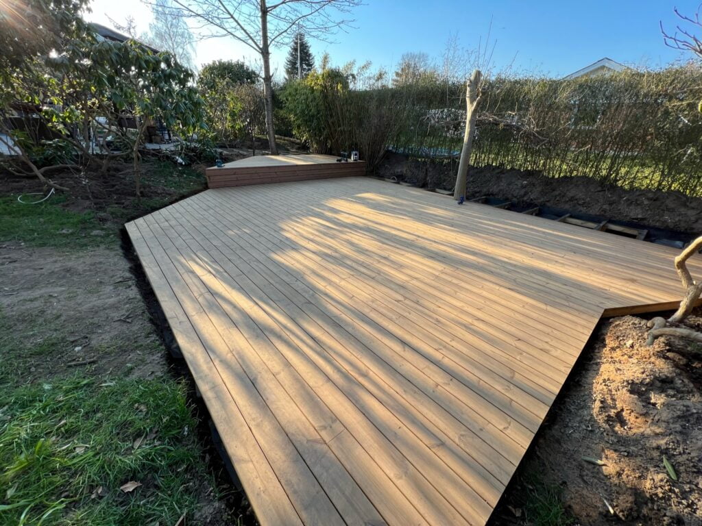 Nybygget træterrasse i solrigt haveområde