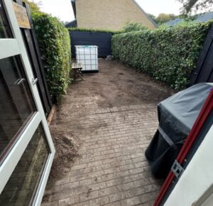 Haveområde med fliser og hække under forberedelse